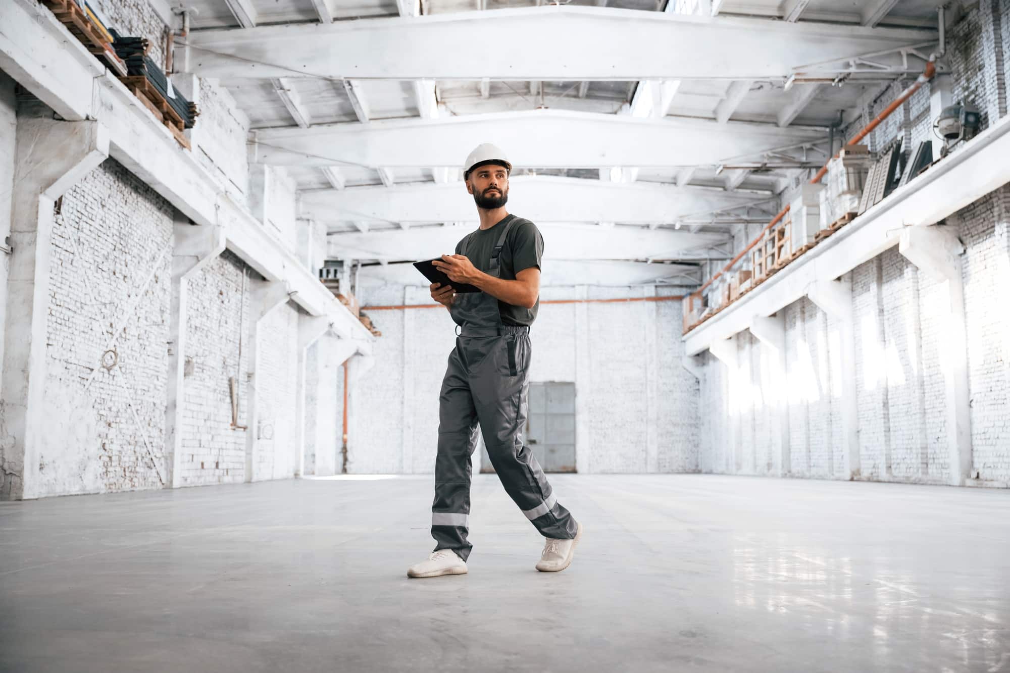 Painted in white. Male worker is in the empty warehouse